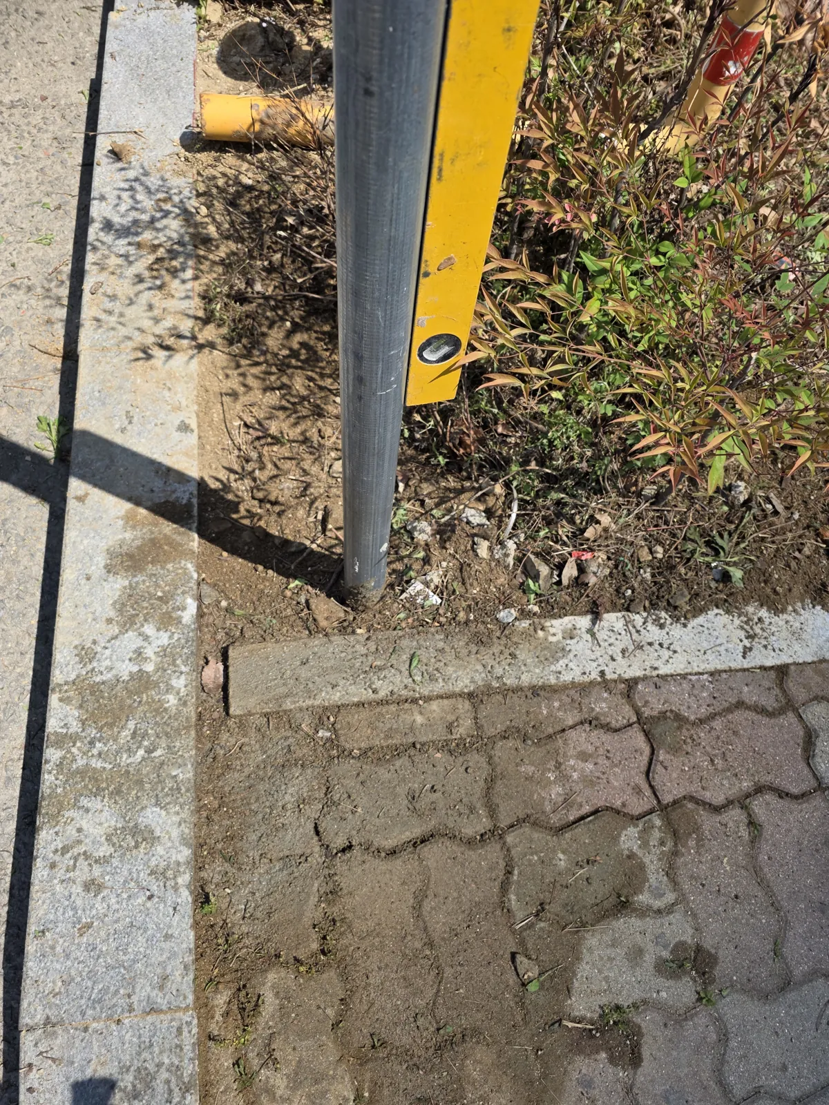 화단 옆 길게 이어진 화강석 경계석과 수평 확인 장면